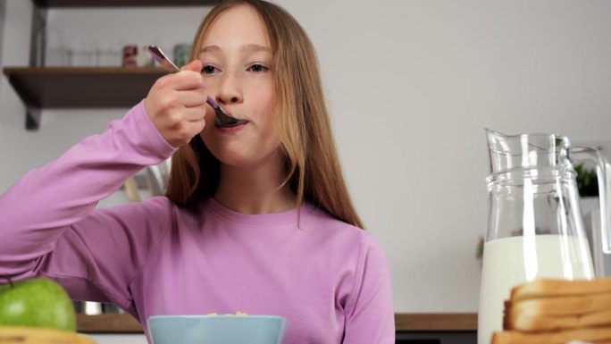 少女坐在厨房享受营养早餐电影特写女孩的一天从关心和健康的膳食开始。精心准备的早餐是孩子早晨快乐的源泉
