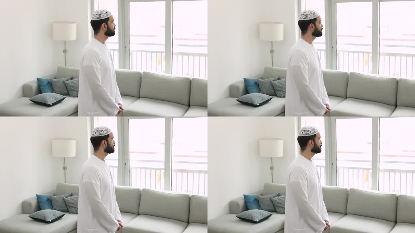 沉默的穆斯林男子穿着传统的kandura站在客厅里