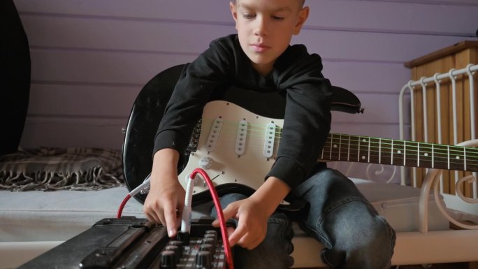 小男孩在家里弹电吉他唱歌。4k视频片段UHD 3840x2160