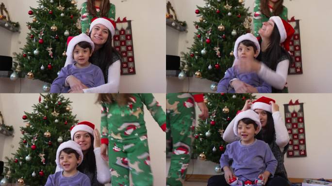 母亲与孩子合影的全家福，以圣诞树为背景。妈妈和儿子戴着红色的帽子，坦率而真实的童年记忆