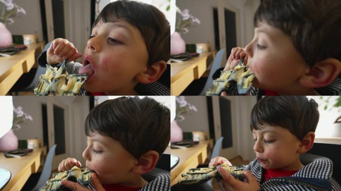小男孩舔着厨房里的搅蛋器里剩下的最后一点浆糊。5岁的孩子在午餐时间舔土豆泥
