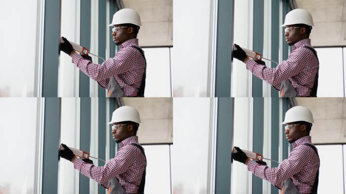 非洲窗户安装工人在安装pvc窗户时使用硅胶泡沫