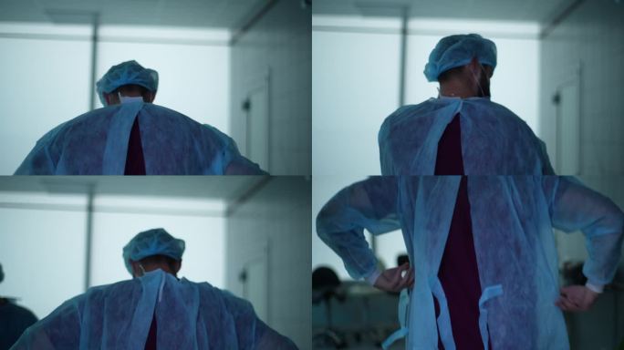 手持拍摄的不知名的男外科医生穿上工作服，准备在医院做手术。医生后视图放睡衣