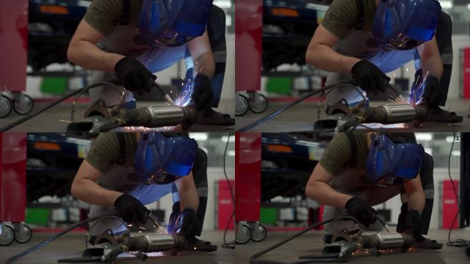 汽车修理工在车库用焊接设备焊接汽车排气软管，在车下进行催化剂修复。专业从事汽车排气系统维修，修理损坏