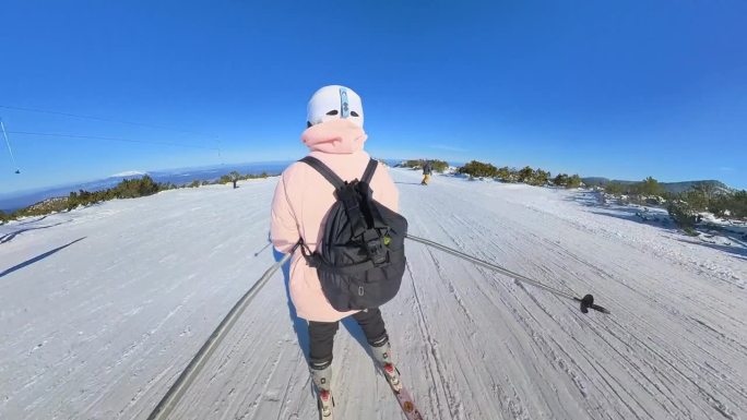 年轻的业余女子滑雪下山。