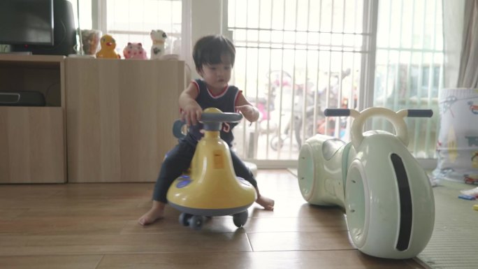 快乐的亚洲男孩在玩玩具车。有趣的骑。