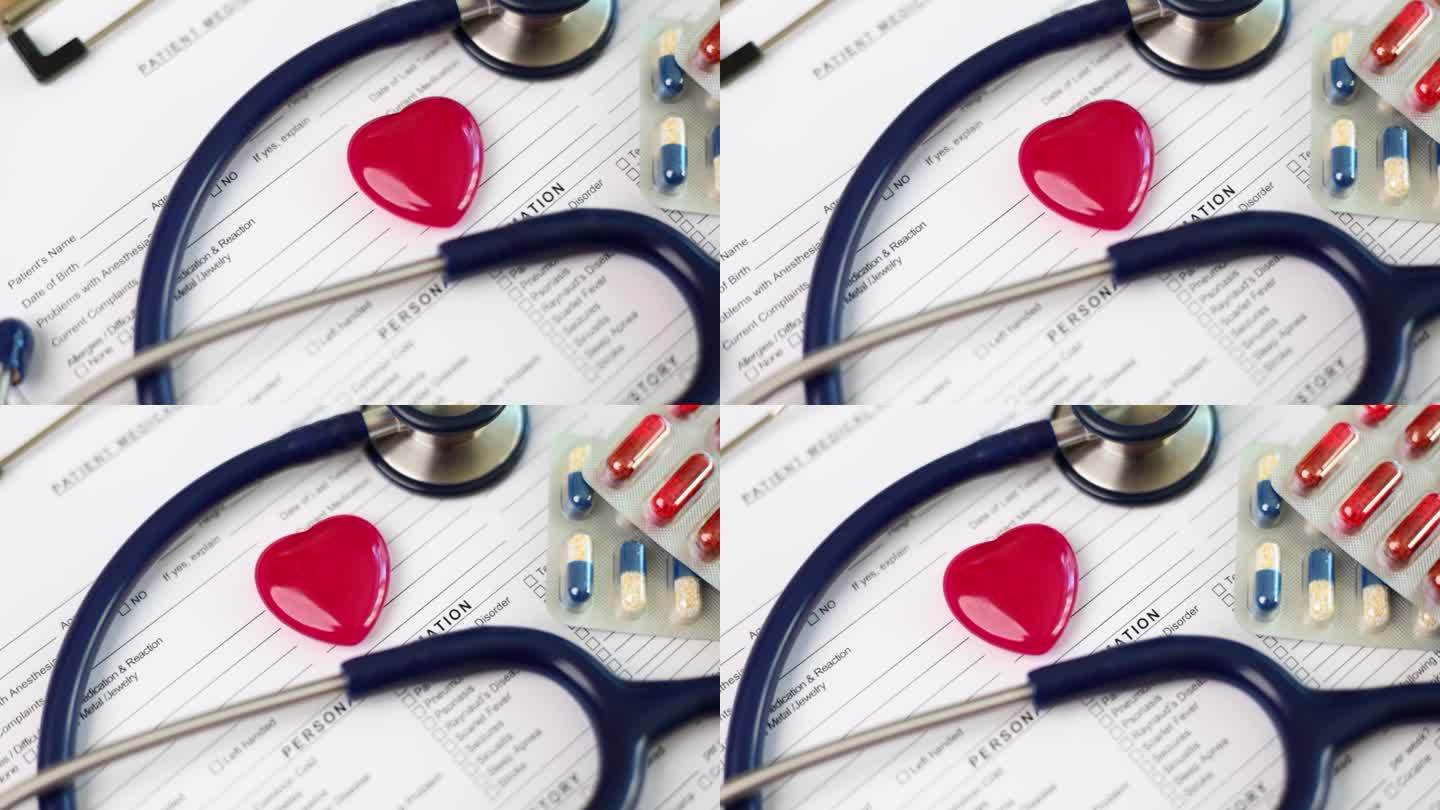 听诊器和红色的玩具心脏躺在医疗文件的特写4k电影慢动作
