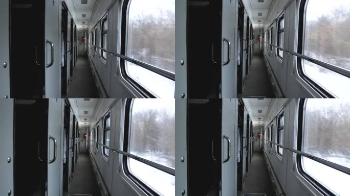 火车车厢里面。通过走廊和窗户，你可以看到冬天的风景。