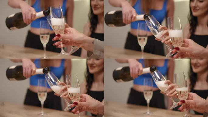 特写镜头。女孩们手里拿着又高又细的玻璃杯，杯子放在一个长柄上，其中一个女孩往杯子里倒白起泡酒。