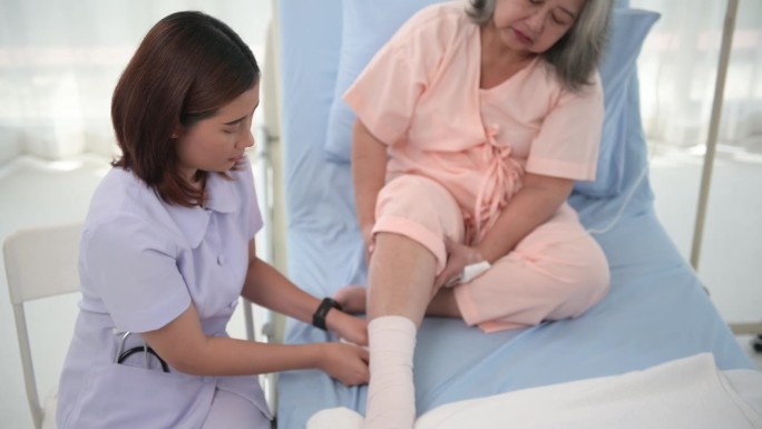 亚洲女护士为老年妇女病人包扎足部