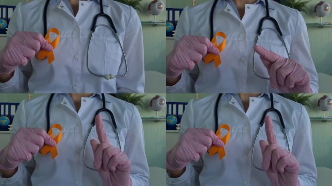 医生拿着橙色的白血病、癌症、多发性硬化症和多动症的宣传丝带