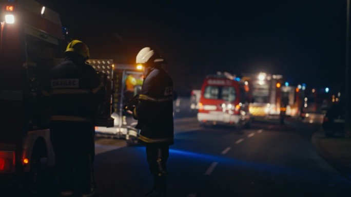 夜间紧急情况下，救援队在消防车附近工作