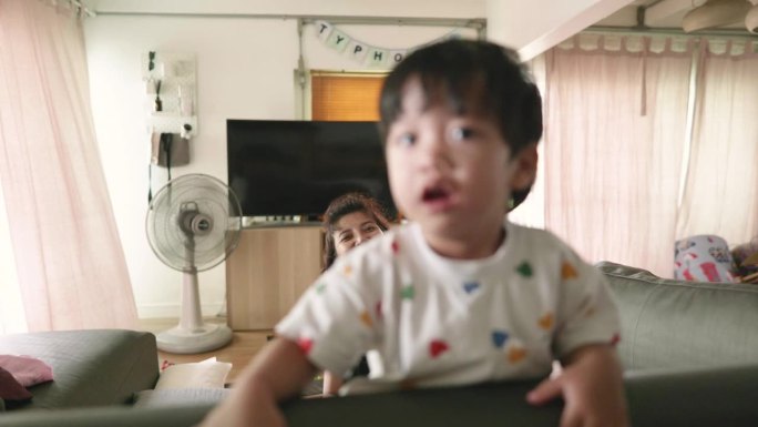 亚洲母亲和儿子玩鬼把戏。在家享受活动