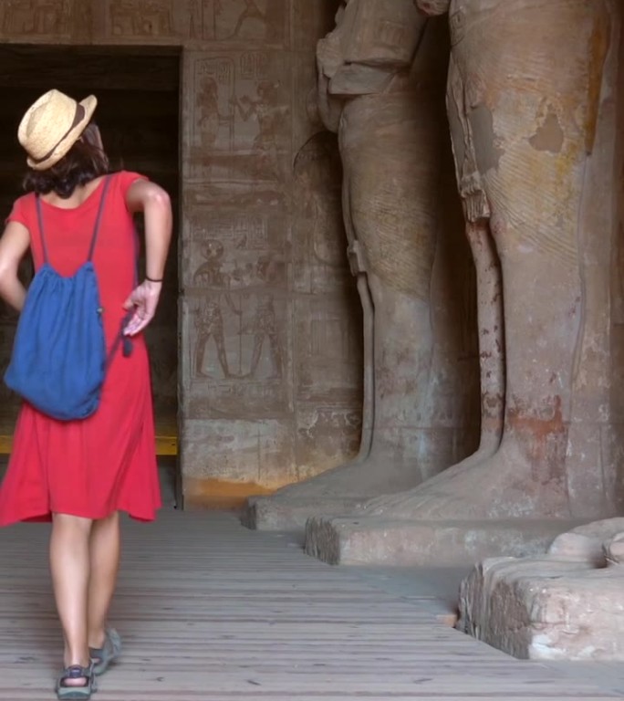 一位年轻的游客正在参观埃及南部努比亚纳赛尔湖旁的阿布辛贝神庙内的雕塑。法老神庙拉美西斯二世，4k视频