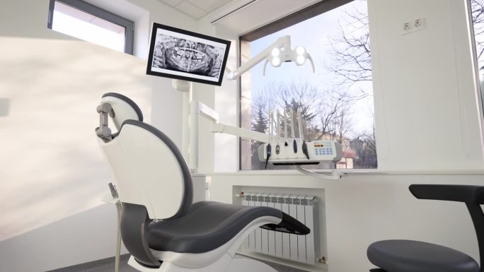 牙科诊所拥有专业的现代化设备。空的极简主义口腔办公室，配有牙科单元，椅子和专业设备。诊所的牙科椅牙医