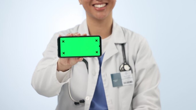 女人，医生和手机，绿屏广告，背景是工作室。女性、医疗或保健外科医生指向手机显示屏、健康应用程序或模型