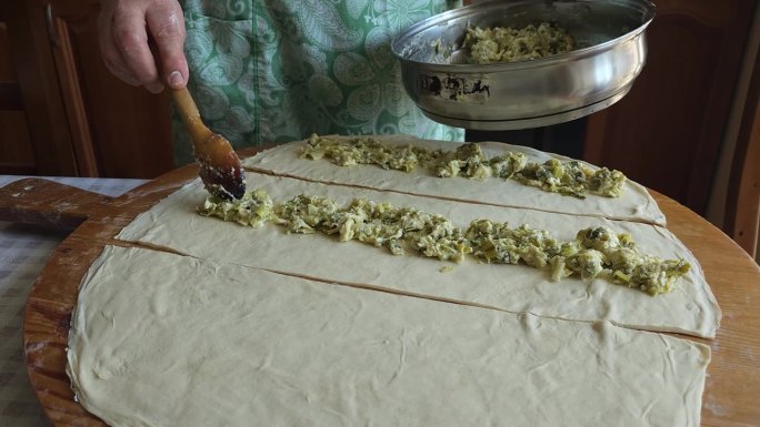 奶奶用勺子把馅料舀到馅饼上——一个温暖人心的烹饪工艺传统