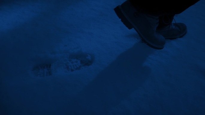 一个人在夜间行走在雪地里