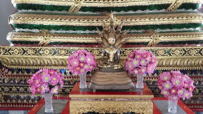 镀金的星期六佛像在曼谷卧佛寺被那迦多头蛇保护
