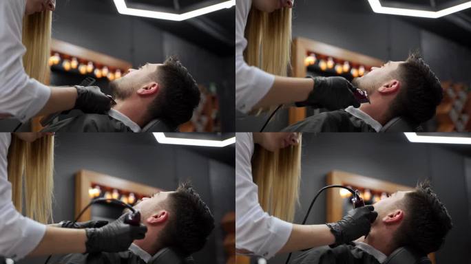 在现代沙龙里，专业理发师给男顾客理发。专业的发型师用剪子、剪刀为时髦的男士做发型。仪容整洁，理发精准