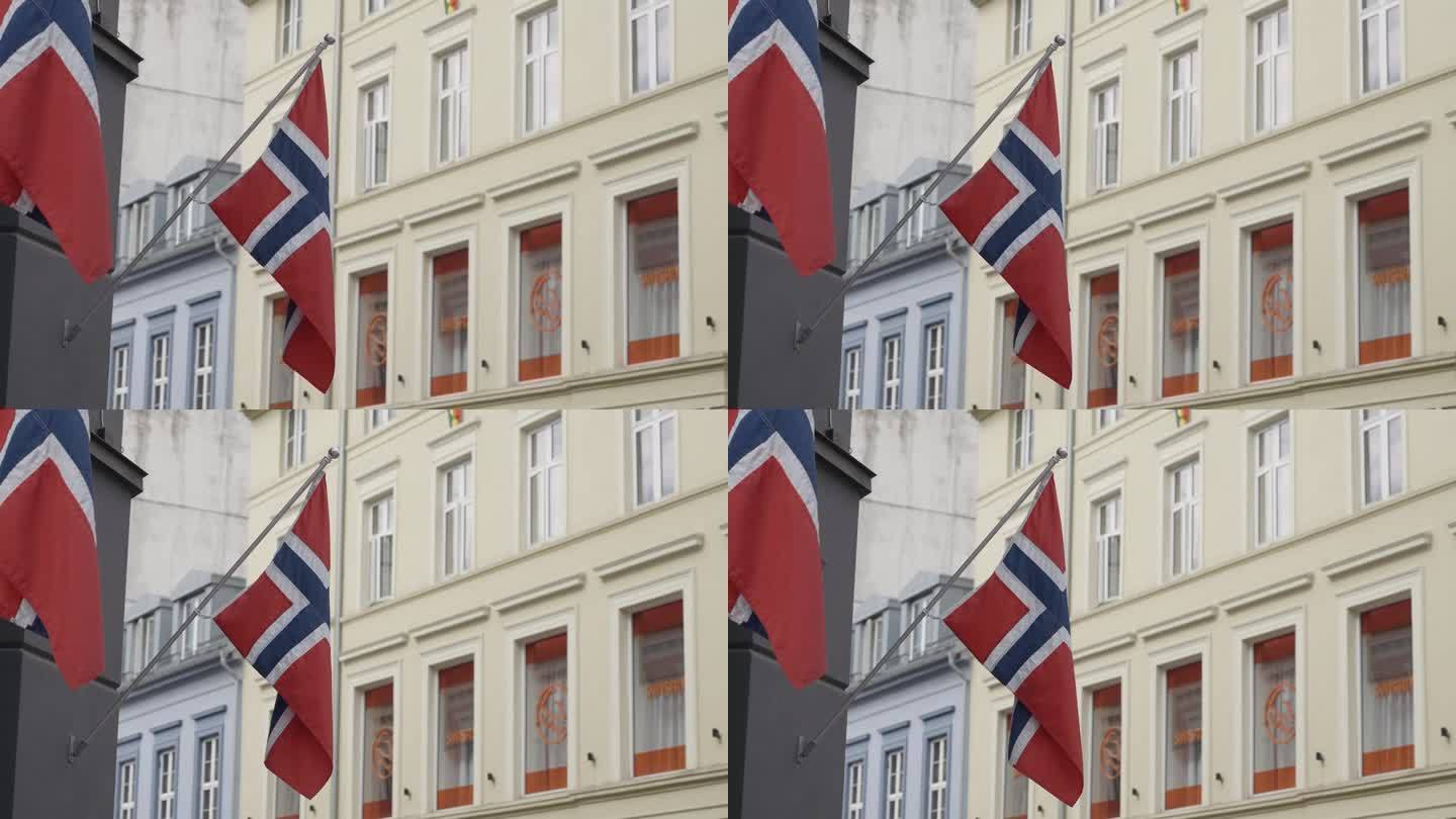 去挪威旅游。行动。狭窄的街道上有两面挪威的红旗。