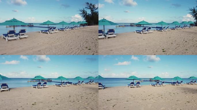 轨道无人机拍摄的白色沙滩上的椅子和雨伞