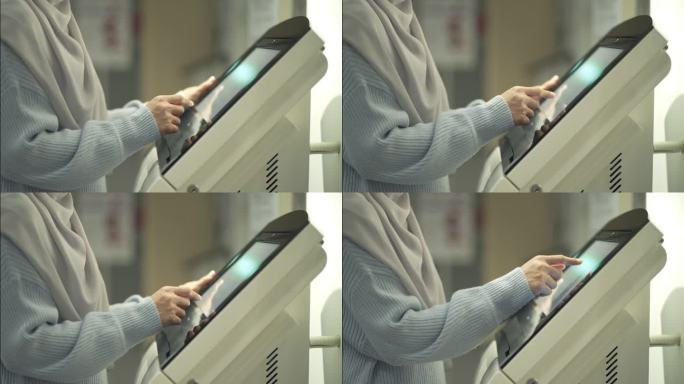 年轻的穆斯林妇女使用触屏显示器的特写