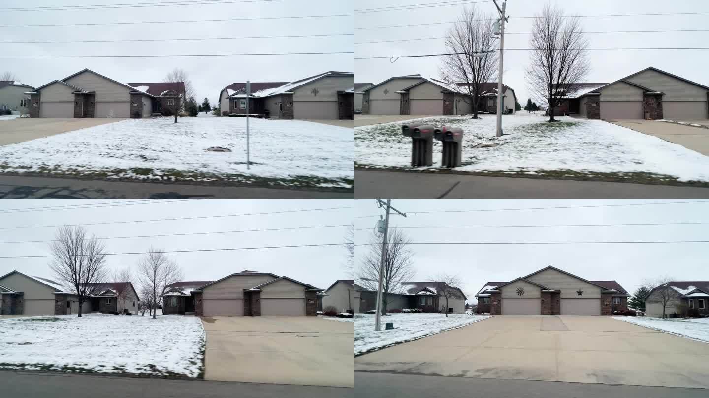 在一个下雪天，在Dike, IA开车经过多户住宅的侧车视角镜头。