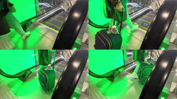 在机场，人们带着他们的行李箱步行，然后登上绿色的自动扶梯下楼。