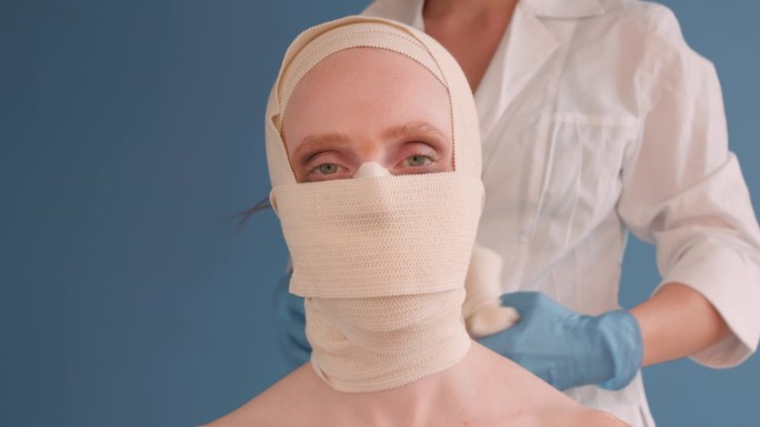 剪短的医生的手臂从女性苍白的病人头上取下绷带