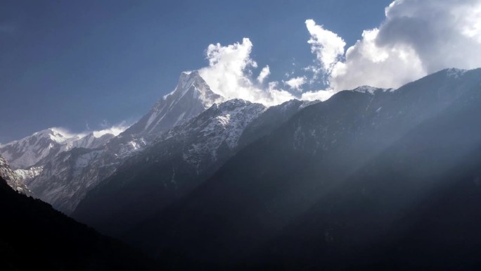 阳光穿过马尔迪喜马拉雅山脉上空的云层，与Machapuchare