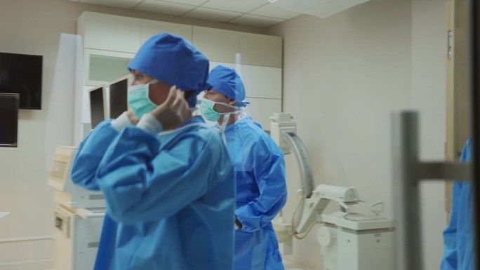 专业医生戴着手术帽走进手术室。有吸引力的专科医生、外科医生、医疗团队和助理在医院工作和准备进行外科手