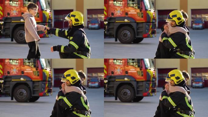 勇敢的消防员在消防车旁拥抱一个小男孩