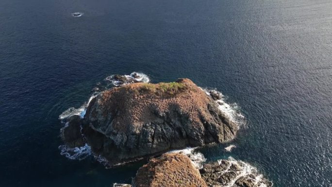 无人机拍摄的小岩石岛屿被海浪碾压