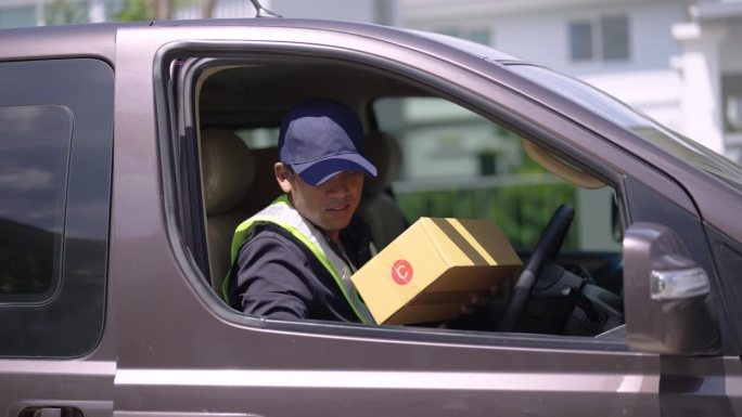 送货员在运输车上准备好包裹，并将箱子送到客户家中。