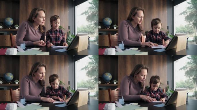 孩子男孩和母亲做折纸玩具使用彩色纸的步骤，按照指导的视频教程在数字平板电脑上