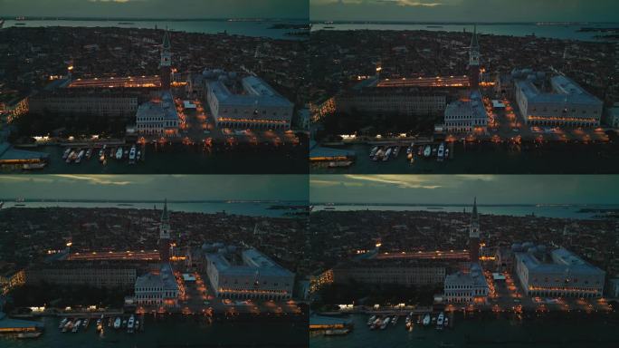航拍实时镜头俯瞰圣马可广场与圣马可大教堂和人群游客散步和观光在城市的主要公共广场在夜晚，威尼斯，意大