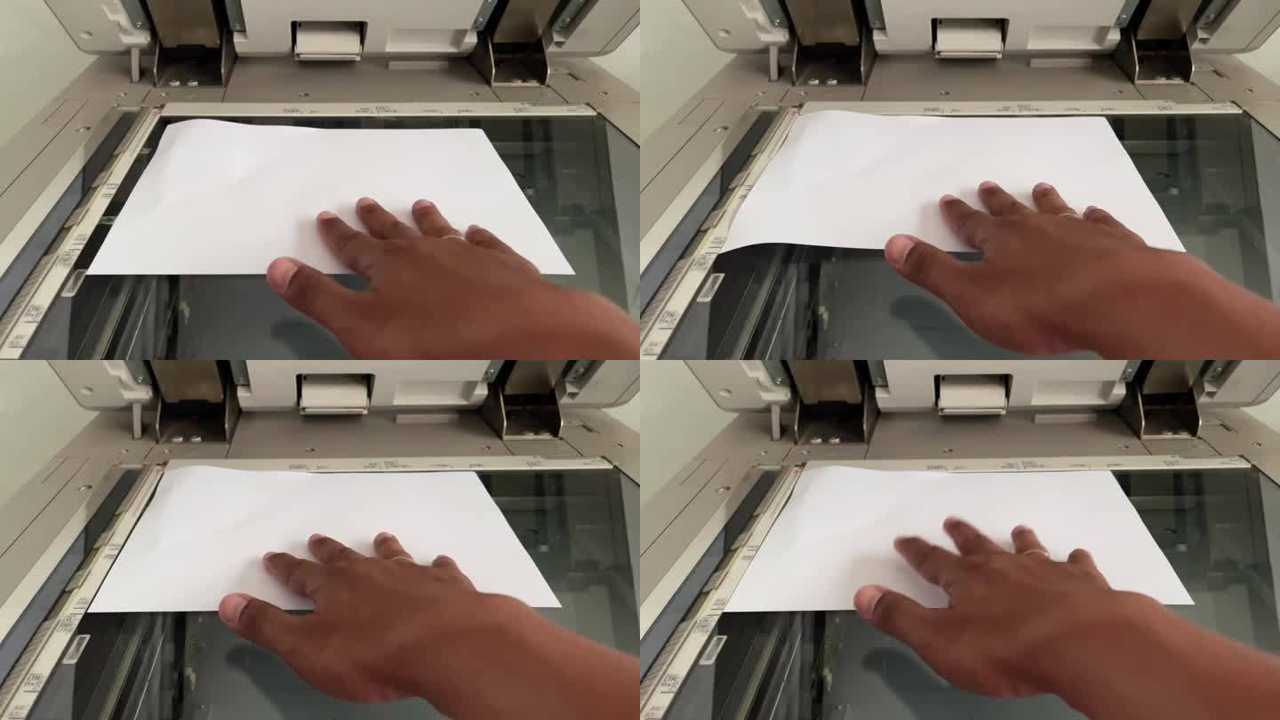 人们的手把纸放在复印机上。复印过程