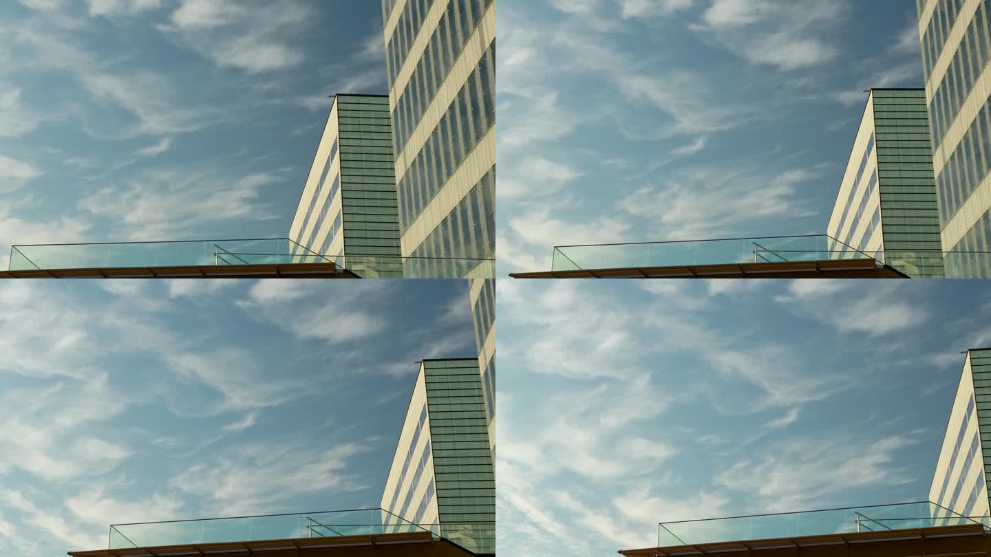 一幢现代办公大楼的一角，蓝天上飘着缕缕白云