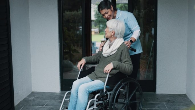 老年妇女，轮椅和护士帮助在养老院外提供服务和照顾者。讨论，微笑与残疾人一起与专业护理人员愉快交谈