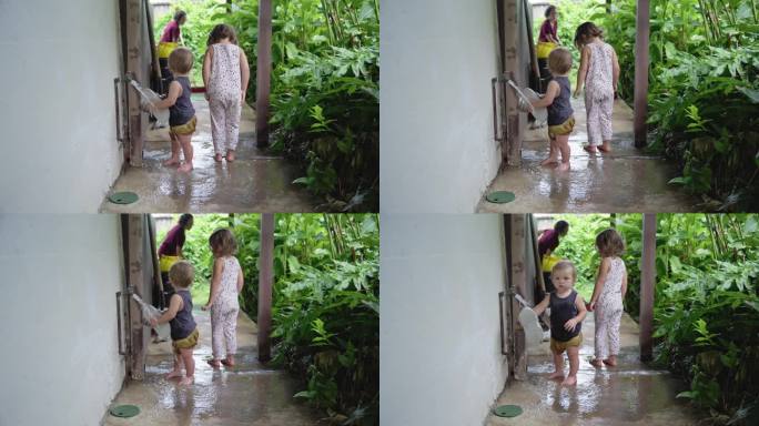 快乐的蹒跚学步的男孩在外面和他的姐姐玩耍