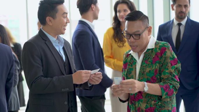 一群不同类型的商务人士在会议或研讨会结束后互相握手问候，交换名片。公司办公室沟通。连接的人。亚洲