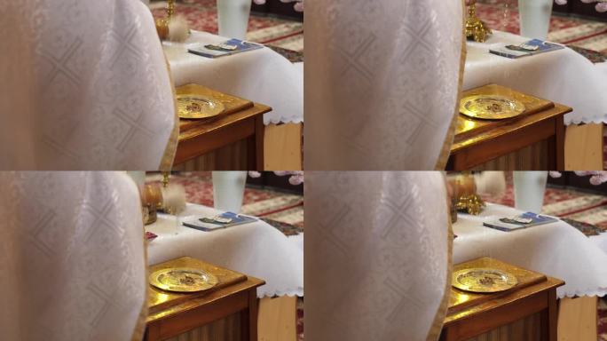 在教堂举行婚礼时，牧师将圣水洒在结婚戒指上。教堂婚礼传统。