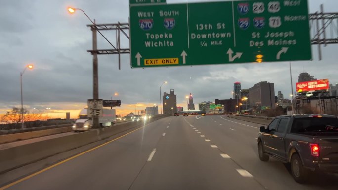 在多云、灰色的日子里，行驶在I-70州际公路上穿过堪萨斯城市中心的汽车驾驶视角