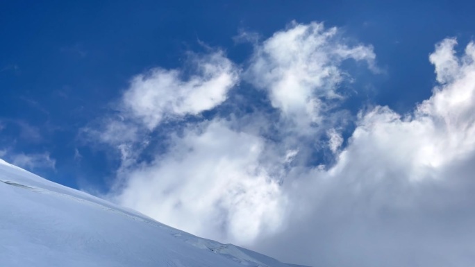 哈萨克斯坦(Kazbegi)峰顶5054米，蓝天白云，雪坡上疾风飞舞。残酷的霜冻天气条件高加索山脉景