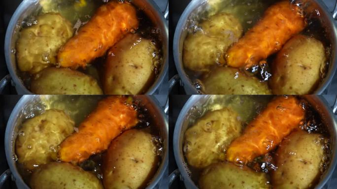 炖锅里有带皮的土豆和胡萝卜，在煤气炉上用沸水煮