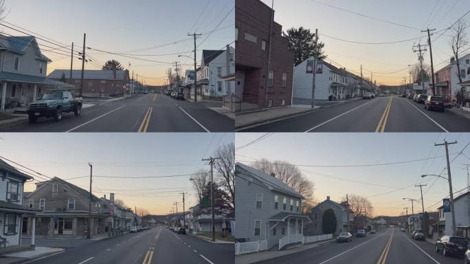 在日落之后的一个晴朗的夜晚，宾夕法尼亚州沙特尔斯维尔的一条老城道路两旁排列着房屋和企业，向前移动的汽
