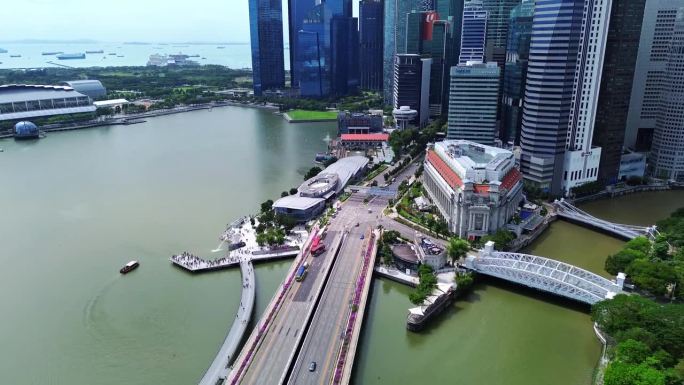 鱼尾狮与拥挤的游客的4k航拍画面。背景是高耸的摩天大楼，这是新加坡的标志。