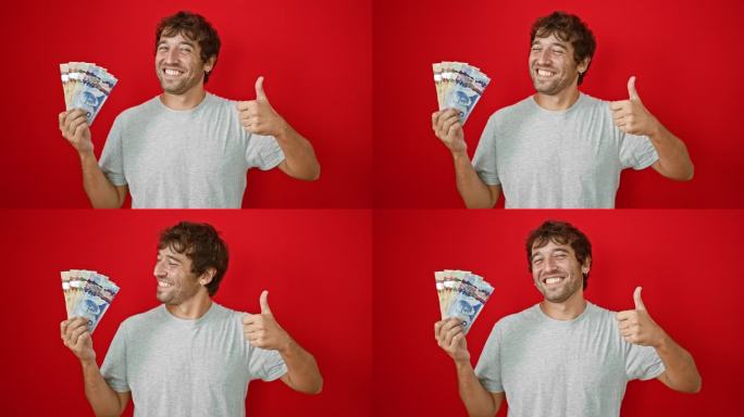 一个开朗的年轻人露出灿烂的笑容，手里拿着加元钞票，在鲜亮的红色背景下做着“ok”的手势