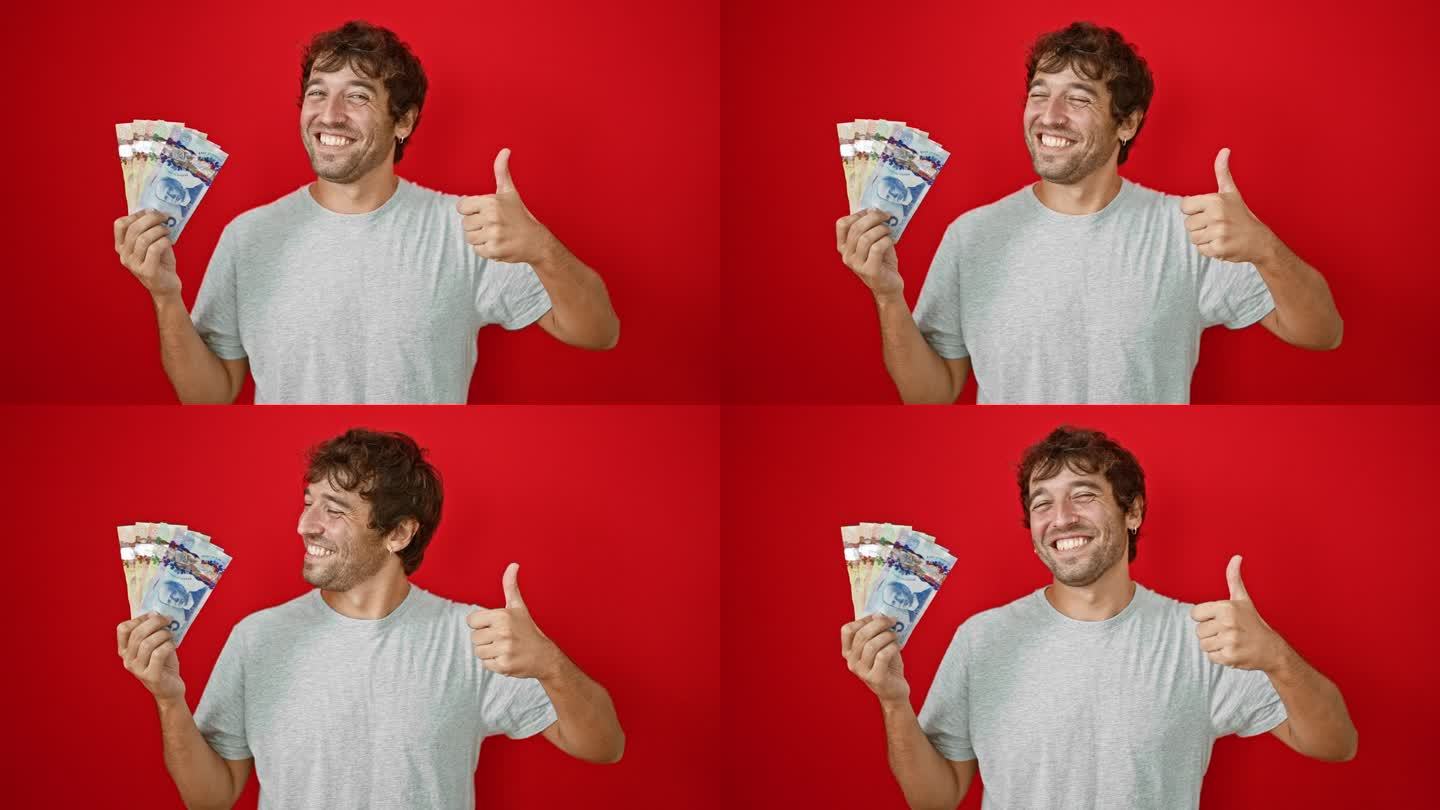一个开朗的年轻人露出灿烂的笑容，手里拿着加元钞票，在鲜亮的红色背景下做着“ok”的手势